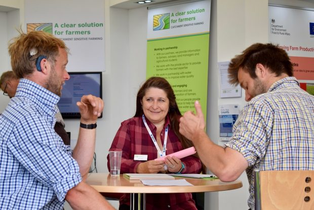 An image of a Natural England meeting with three members of staff having a discussion round a table.