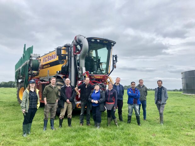 An image of contractors on David Christensen's farm standing in front of a trailing hose