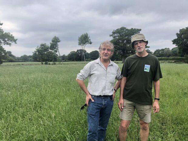 Tony Juniper and Jon Shelton standing in a green field.