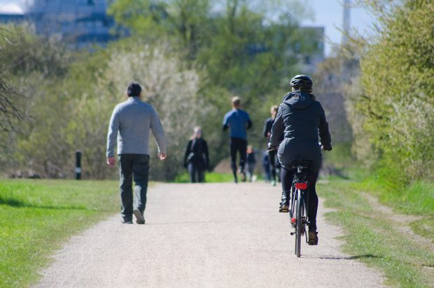 Woman cycling through a park w