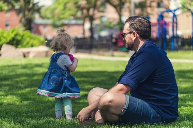 Father and daughter sitting in a park