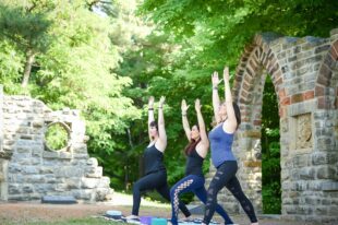 Three women practising yoga in a park