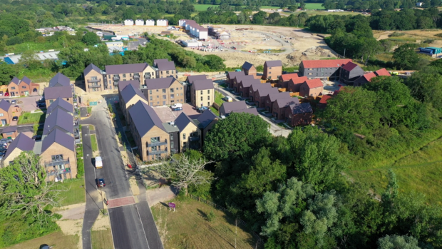 An Aerial view of a development site in progress. Lots of new houses are being built amongst greenery