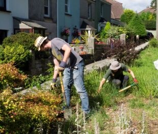 Two people with gardening implements working to improve biodiversity
