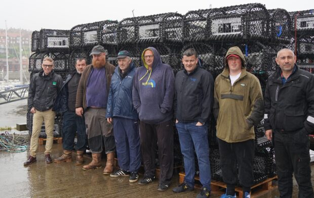 Mark Duffy, Natural England Marine Principal Adviser, far left, with fishermen and representatives from Fishtek at Whitby harbour stood in front of crab pots