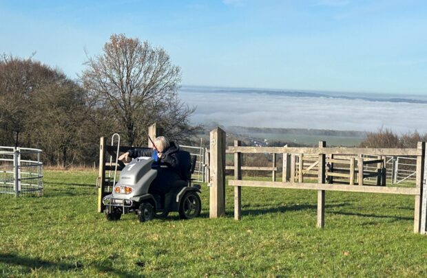 A person on an all-terrain vehicle going through a gate.